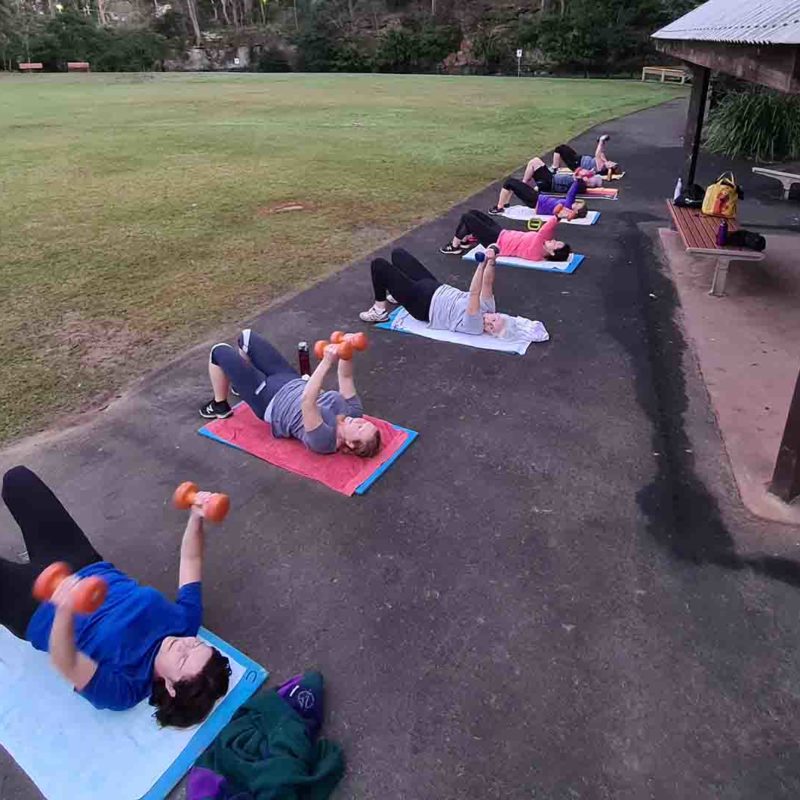Pymble members lying on mats with weights